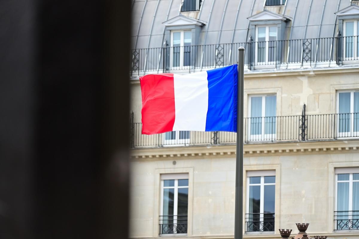 un drapeau de france qui flotte dans une ville du monde