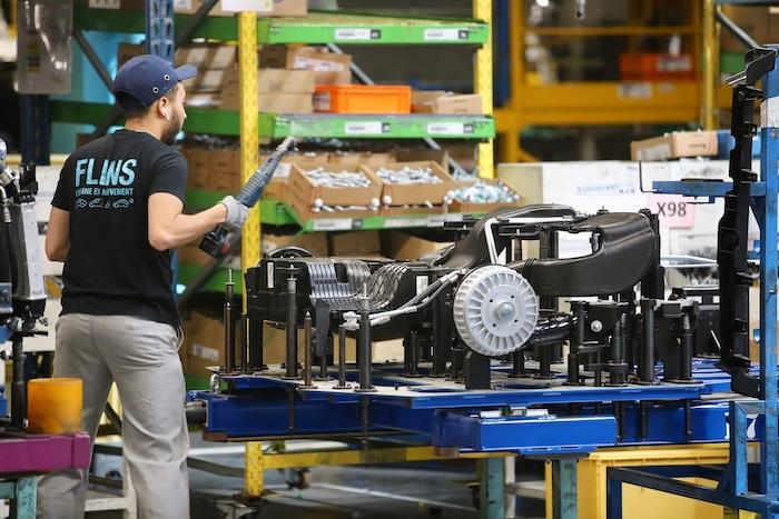 un ouvrier de dos sur un chaine de montage d'automobiles Renault
