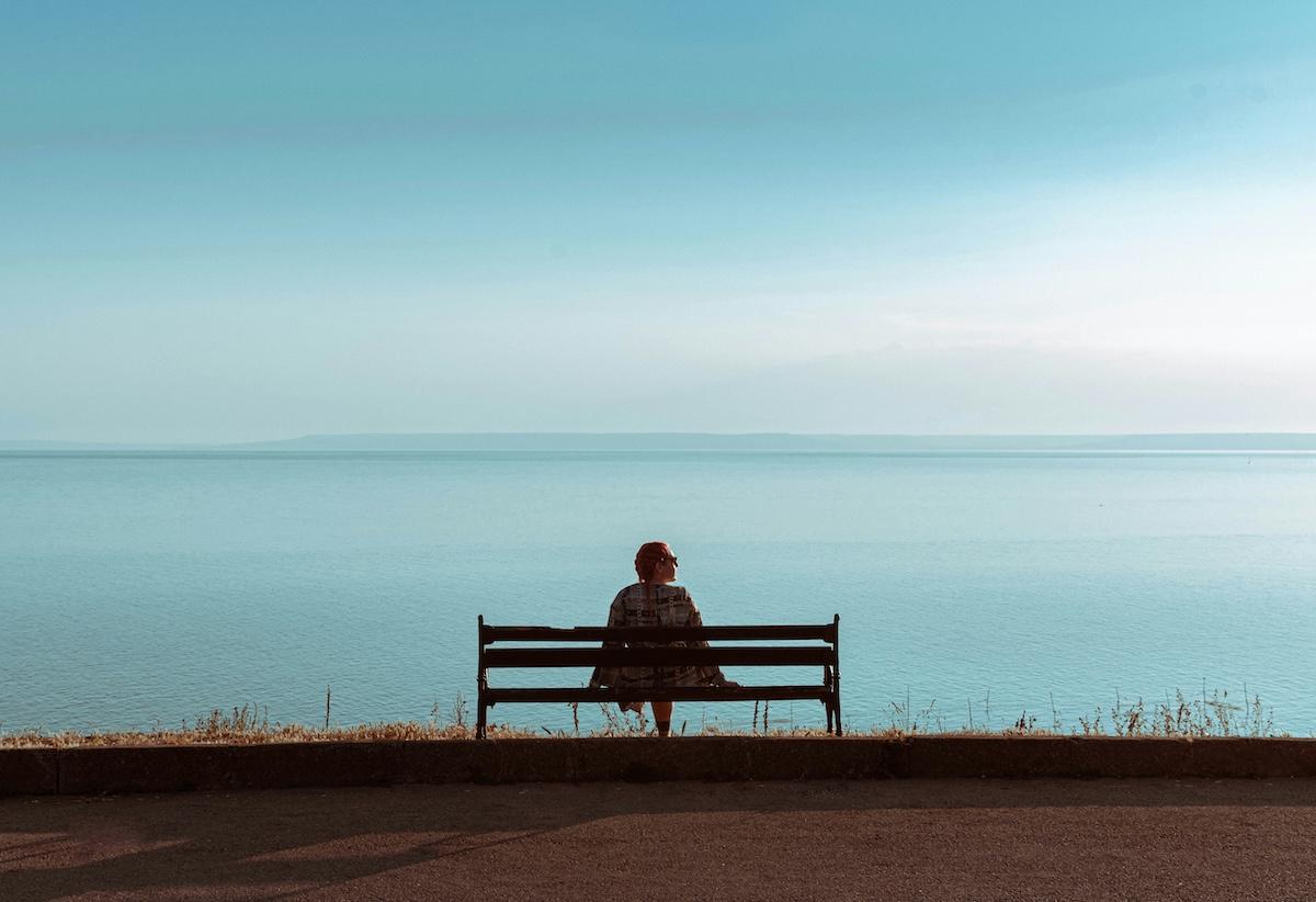 être seul sur un banc face à la mer en expatriation