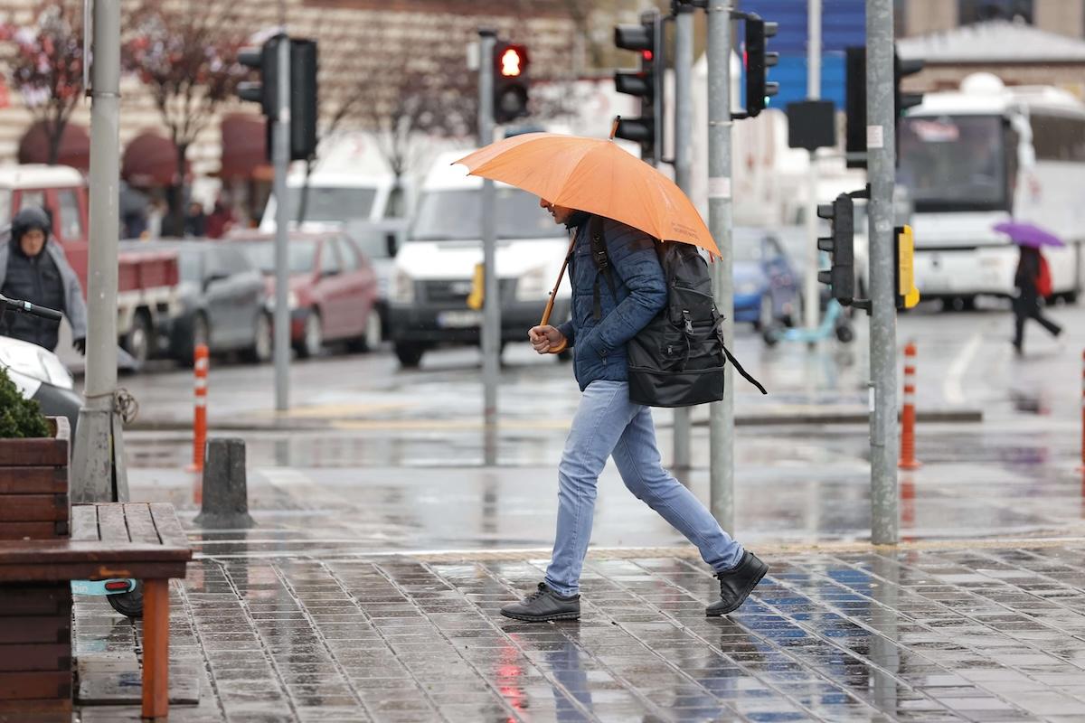 personne marchant sous la pluie avec un paparpluie orange à valence