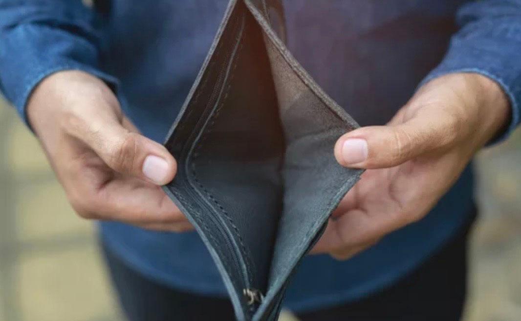 Un homme ouvre un portefeuille vide avec ses deux mains