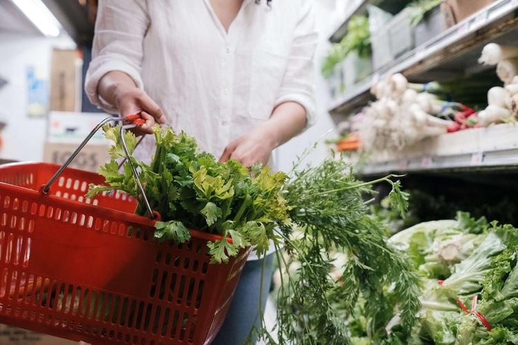 une personne en train de faire les courses en espagne avec son panier rouge