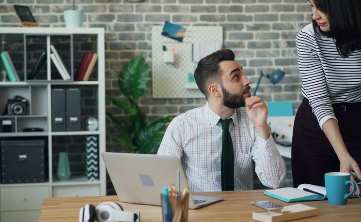 un homme et une femme assis a un bureau dans un bureau