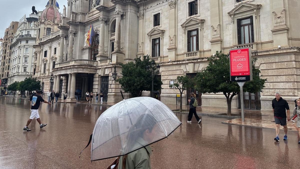 personnes marchant sous la pluie avec un parapluie place de la mairie à valence