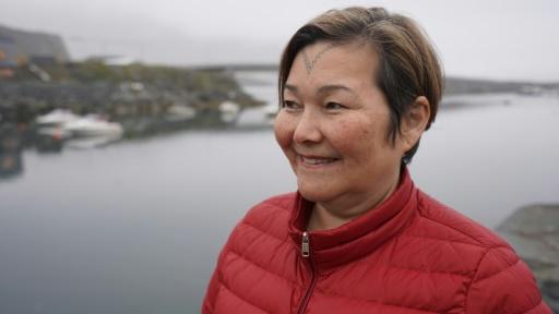 Femme inuit devant une étendue d'eau