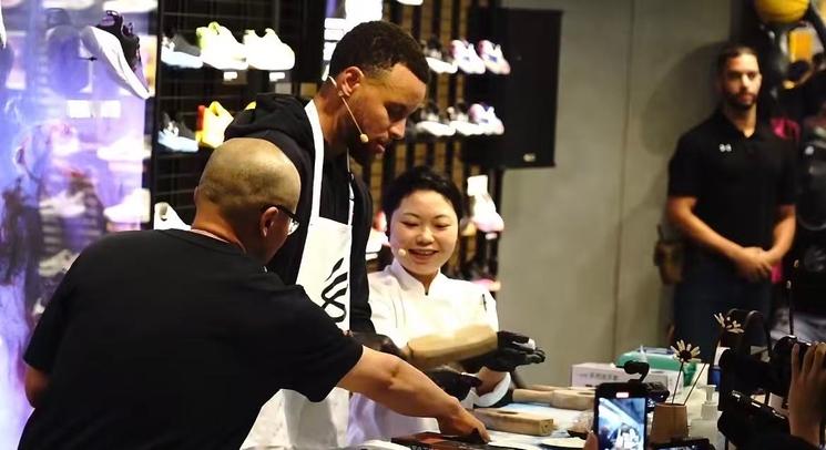 Aimée donnant un cours de cuisine au joueur de basket Stephen Curry