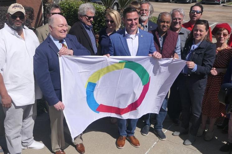 Tenant le drapeau, de gauche à droite, Dave Domingue, Josh Guillory, Peggy Feehan