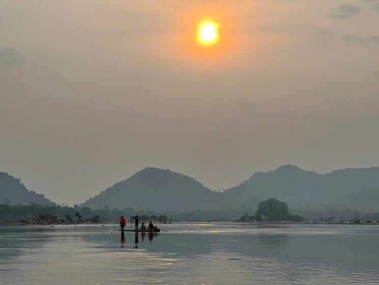 Après-midi du 10 mars 2024. Des pêcheurs sont debout sur un bateau en train de jeter leurs filets sur le Mékong. (Sovann Sreypich CamboJa News)