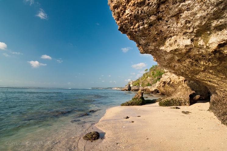 plage de padang padang à bali avec un rocher au premier plan et des eaux cristallines