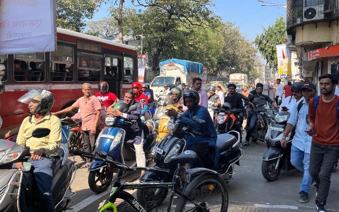 Accumulation de mobylettes et de bus dans une rue de Mumbai à un feu rouge