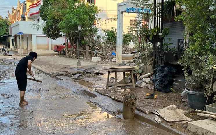 Un habitant de Chiang Mai nettoie la boue laissee par la crue historique de la riviere Ping