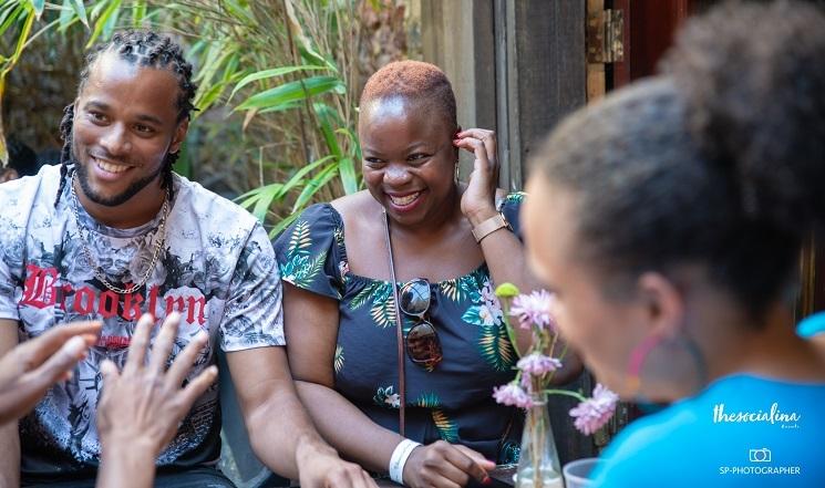 Des gens rient en extérieur, l'ambiance a l'air conviviale