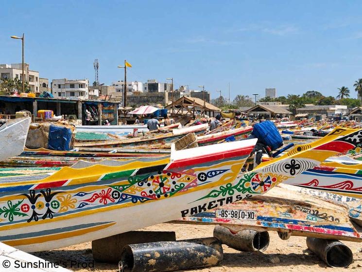Pirogues de pêche colorées alignées sur une plage du port de Dakar, au Sénégal.