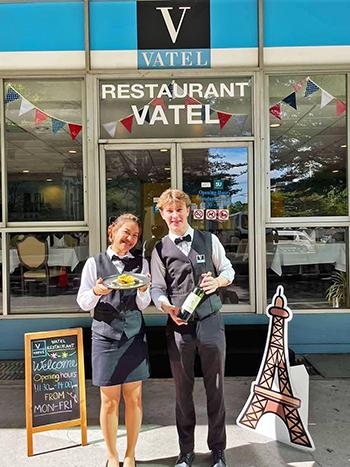 Deux etudiants de l'ecole hoteliere Vatel en Thailande posent pour la photo devant le restaurant d'application