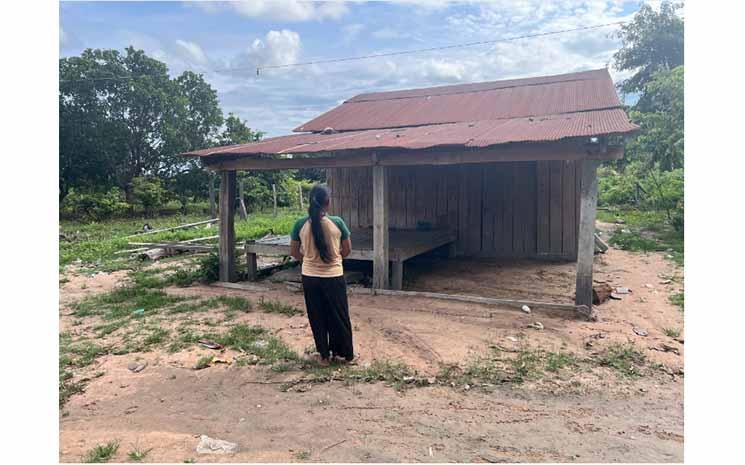 Sreyna se tient devant sa maison dans la province de Ratanakiri, dans le nord-est du Cambodge, où les agents de crédit ont affiché une lettre d'avertissement (Image : Leila Goldstein).