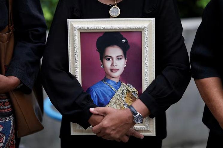 Personne portant un portrait de la reine-mère de Thailande 