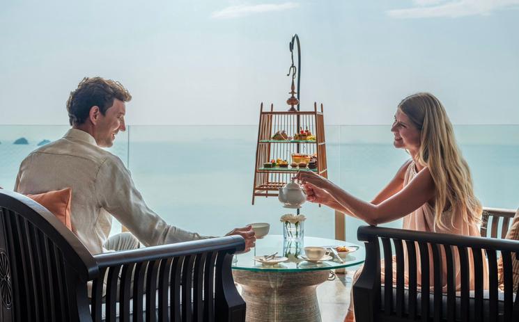 Un couple prend le thé face à la mer