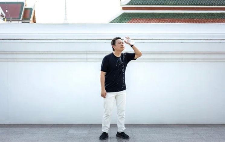 Homme s’arrose avec une bouteille 