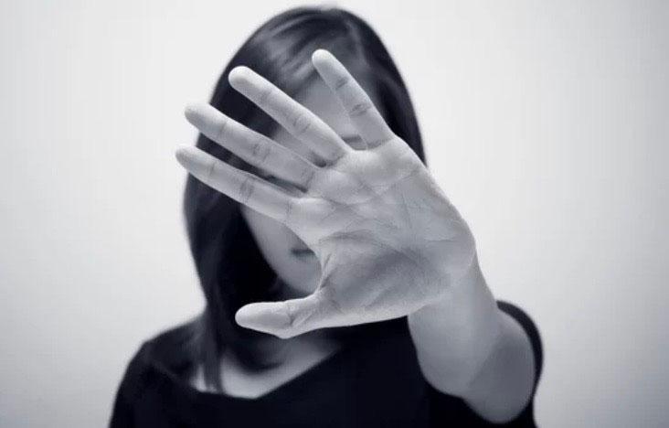 Main de refus devant visage de femme