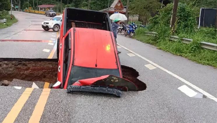 Pick-up plongé dans un trou de chaussée en Thaïlande 