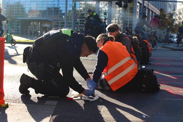 La police applique un produit afin d'éliminer la colle de leurs mains ©Laura Dubois