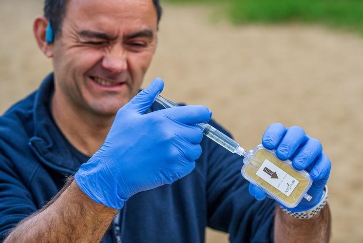 Christophe Gruault prélève des échantillons d'eau afin de collecter de l'ADN scientifique qui permettra aux scientifiques d'analyser les espèces vivant à différents endroits le long de la trajectoire de Christophe. Cet échantillon est prélevé dans la rivière Narew, juste avant qu'elle ne rejoigne la Vistule.