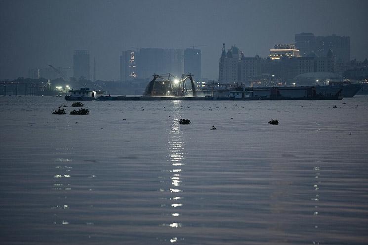 Dragueurs de sable la nuit sur le Mékong à Phnom Penh