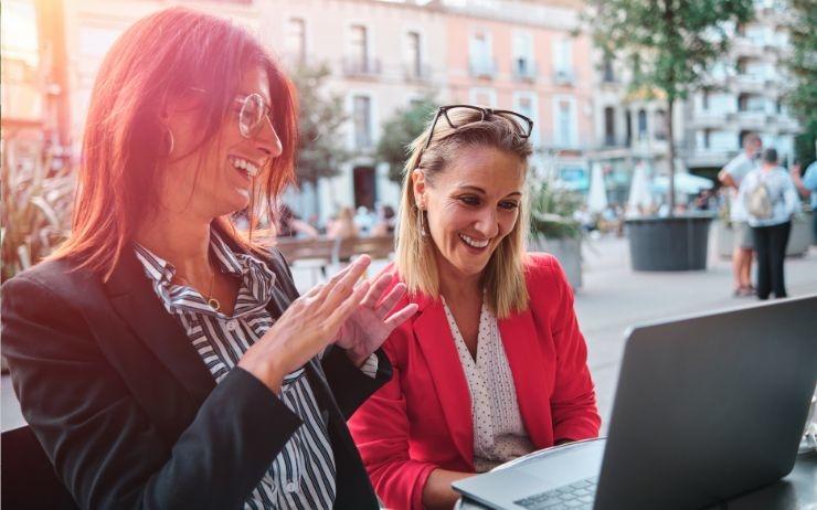deux femmes discutent devant leur ordinateur