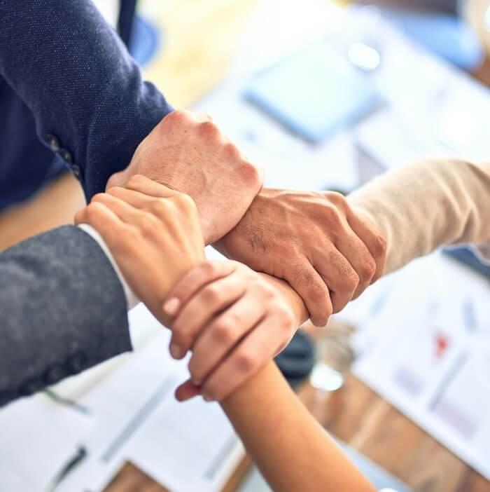 des mains d'une équipe qui se touchent 