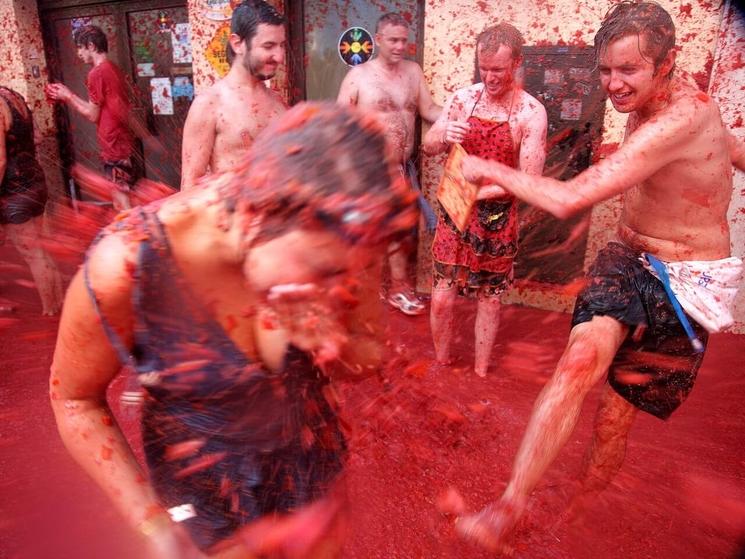 Des hommes en train de se jeter des tomates lors de la tomatina