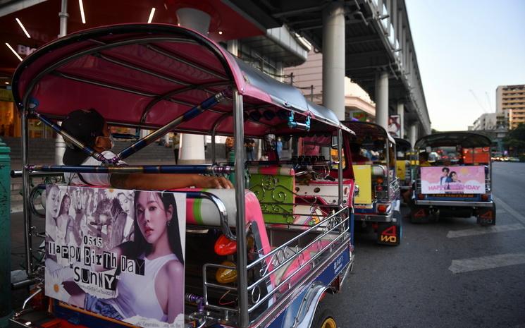 Des tuk-tuk affichant des idoles de K-pop