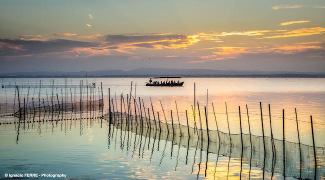 une barque sur le lac de l'albufera au coucher du soleil