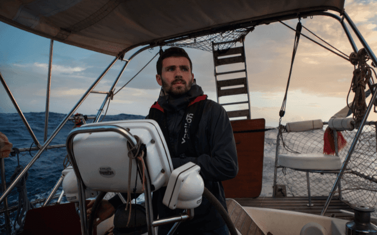 Antonin Jean à la barre d'un bateau 