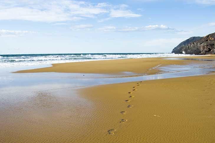 des empreintes de pas sur une plage sauvage en Espagne