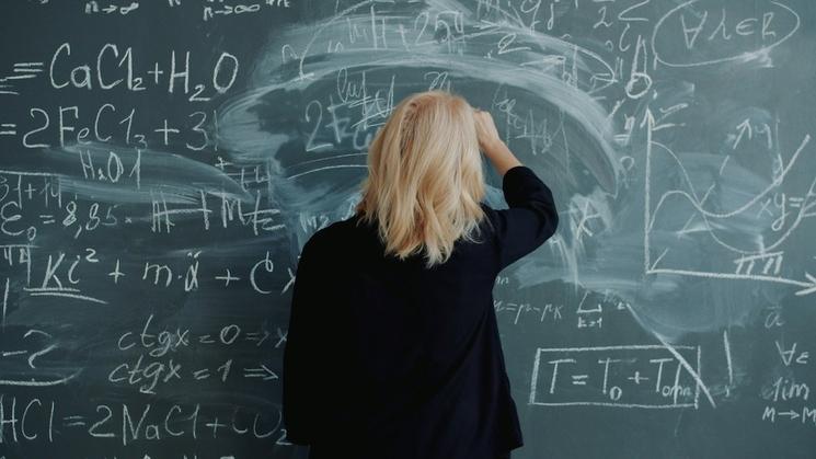 une femme tente de résoudre un problème de mathématiques mais n'y parvient pas 