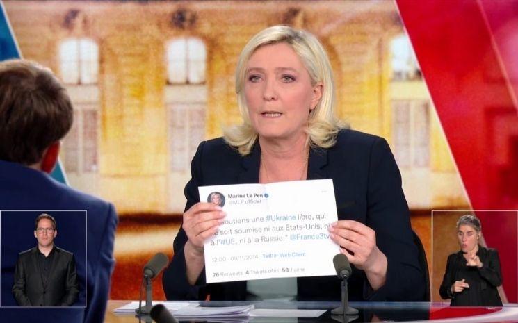 Marine Le Pen brandissant un tweet imprimé