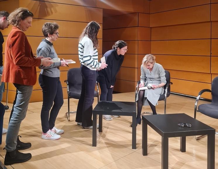 des jeunes qui font la queue pour dédicacer un livre