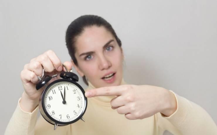 femme en retard avec un réveil