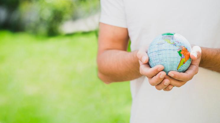 Un homme tient une petite planète Terre entre ses mains