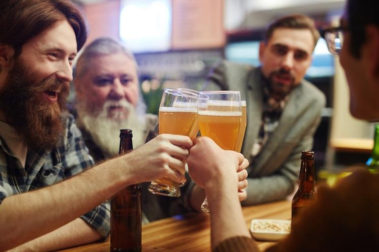 quatre hommes en train de trinquer dans un bar