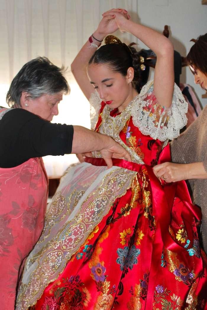 une fallera vêtue d'une robe rouge pour le défilé