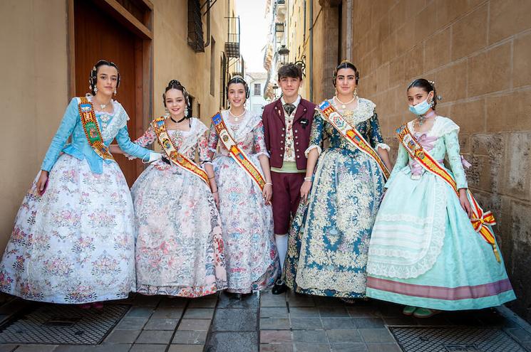 5 filles en robes traditionnelles et un garçon en costume violet au milieu