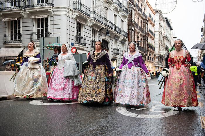 Des falleras en costume traditionnel en train de défiler et d'amener des fleurs à la Vierge à Valencia