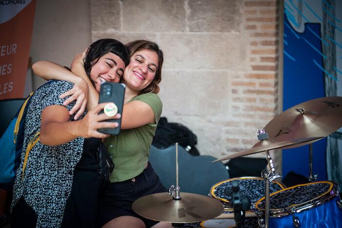 deux musiciennes en train de s'enlacer à côte d'une batterie lors de la fête de la musique