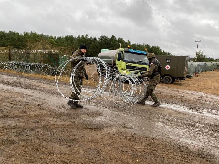 Des gardes polonais installent des barbelés à la frontière