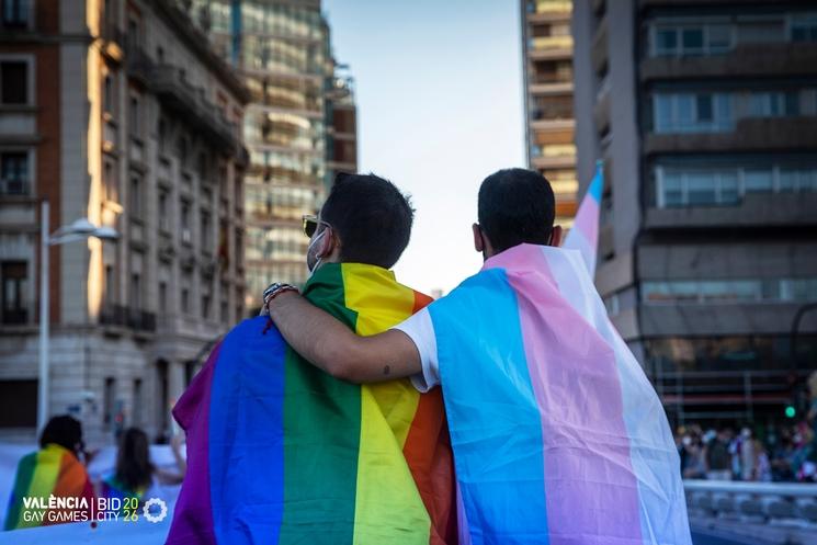 Deux hommes qui se tiennent par l'épaule avec le drapeau LGBT