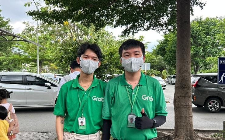 Employés GRAB aidant les voyageurs à trouver leur véhicule après l’avoir commandé depuis l’application