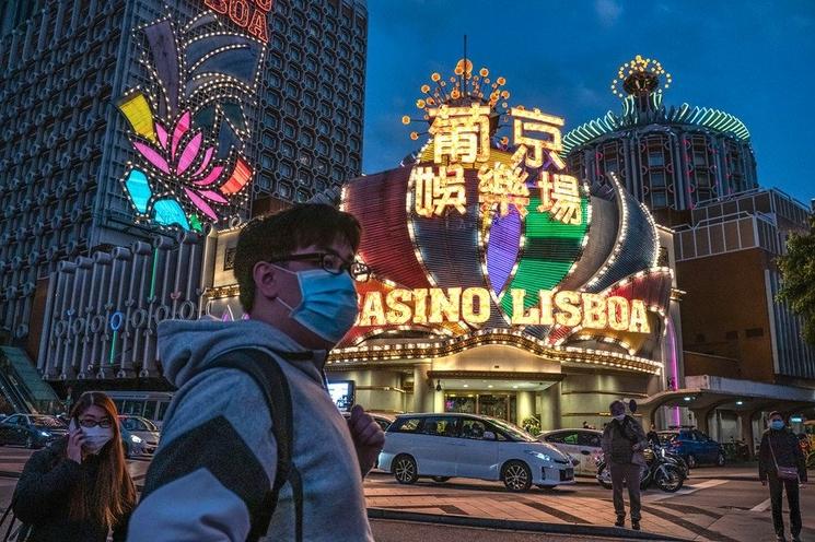 Homme face à un casino avec un masque a Macao