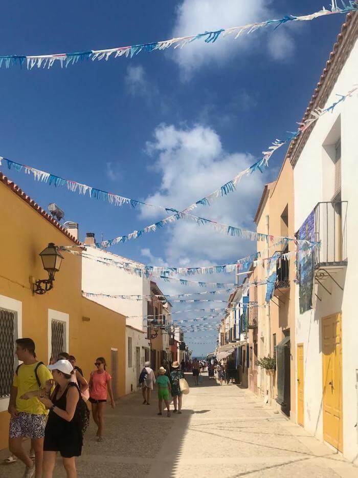 Une ruelle avec des maisons sur l'île de Tabarca et des banderolles dans le ciel 