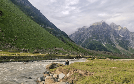 un homme assis en bas des montagnes